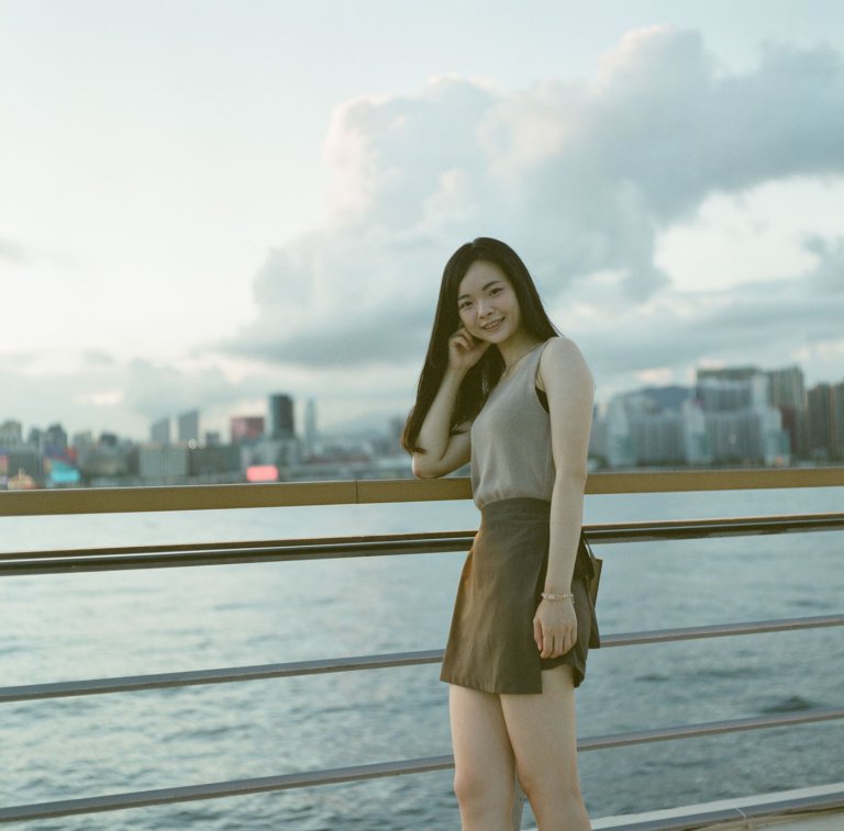 Portrait of young woman by the water with Hong Kong skyline, Oi! urban sunset photo | Urban Elegance 5 of 13