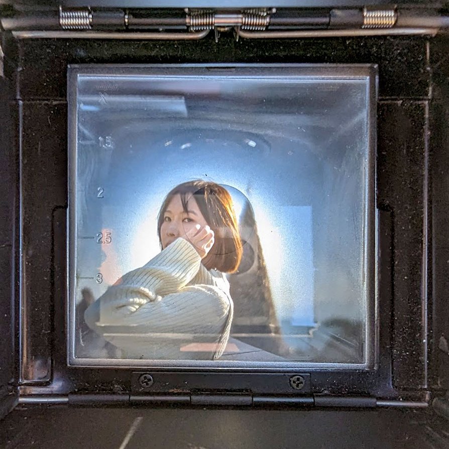 Artistic portrait of a woman seen through the viewfinder of a vintage camera at East Coast Park Hong Kong