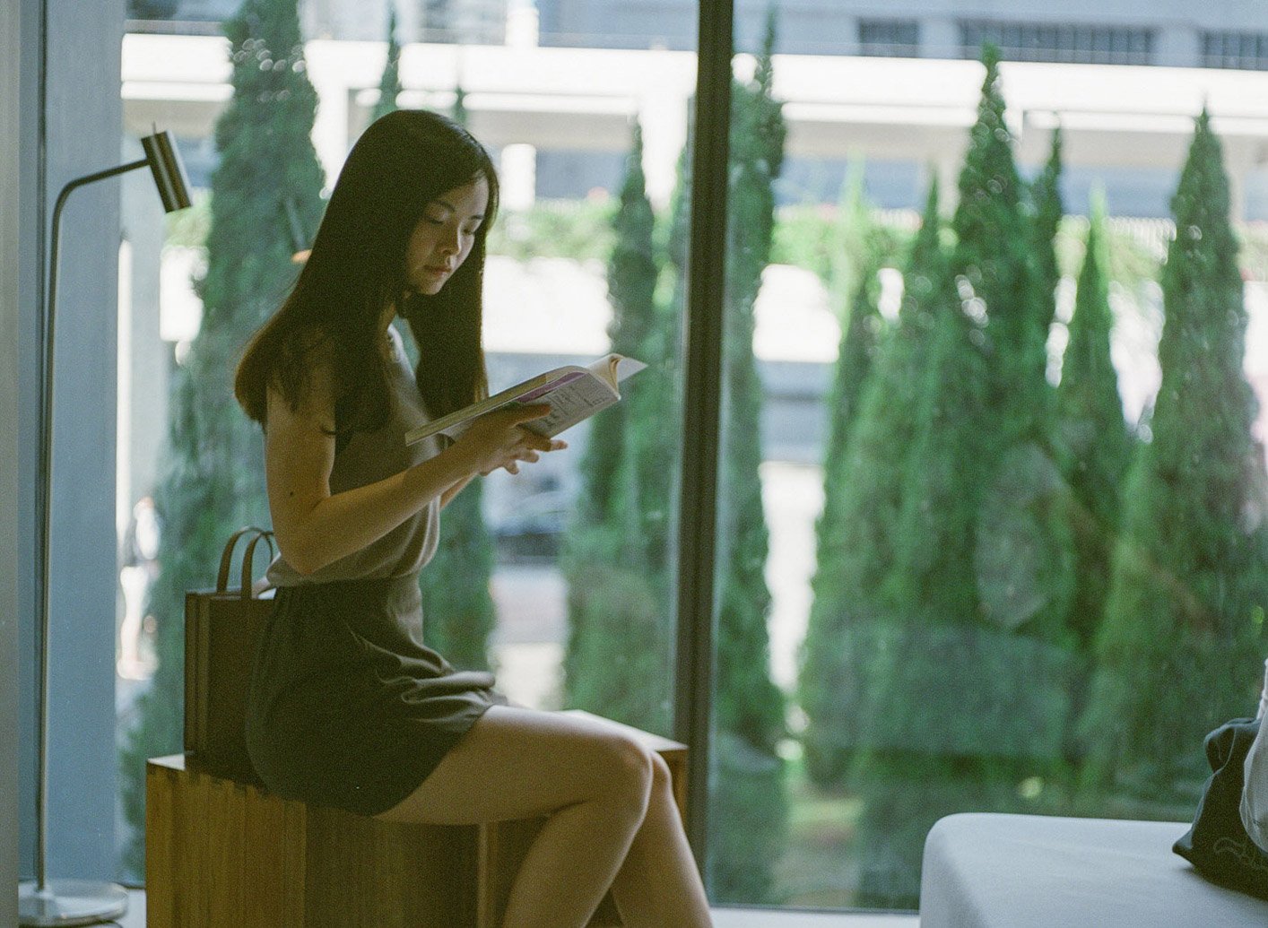 Female model reading book in natural light, interior portrait at Oi! Art Space Hong Kong | Urban Elegance 2 of 13