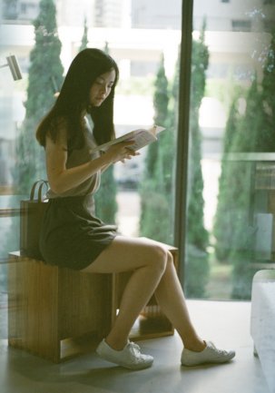 Stylish female model portrait at Oi! Art Space Hong Kong by Victoria Harbour window, casual summer outfit | Urban Elegance 1 of 13