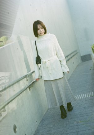 Stylish female model in white sweater posing on the ramp at WKCD, West Kowloon Cultural District, with minimalist architecture and sunshine.